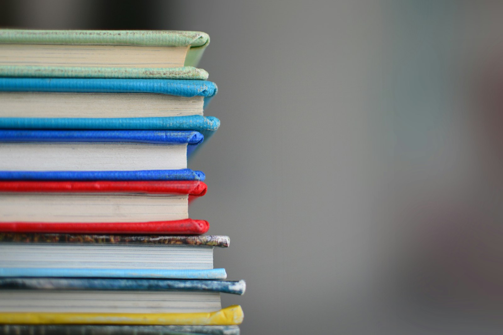 Pilha de livros de capa dura empilhados uns sobre os outros, vistos de lado